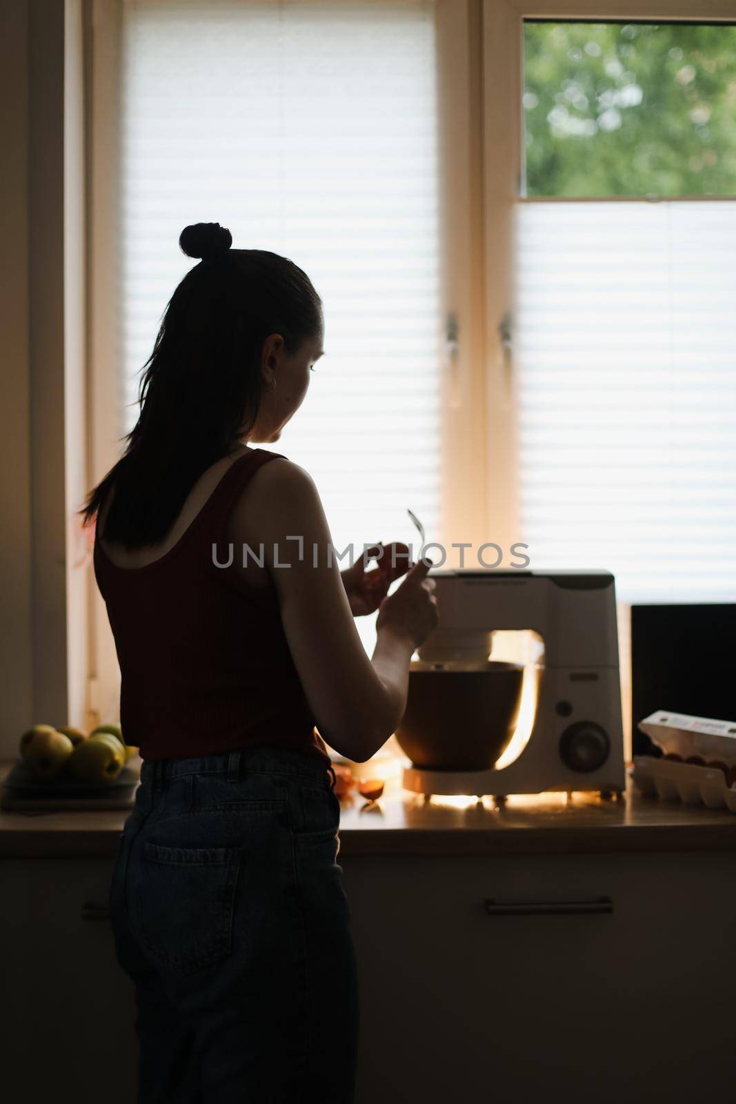 Woman baking at home using kitchen planetary mixer.