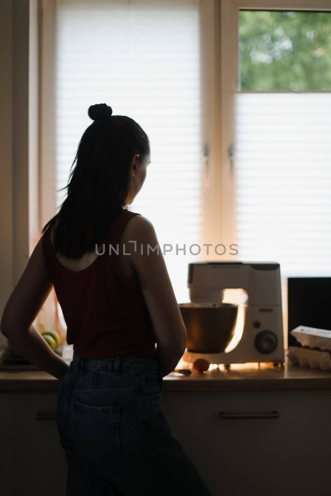 Woman baking at home using kitchen planetary mixer.