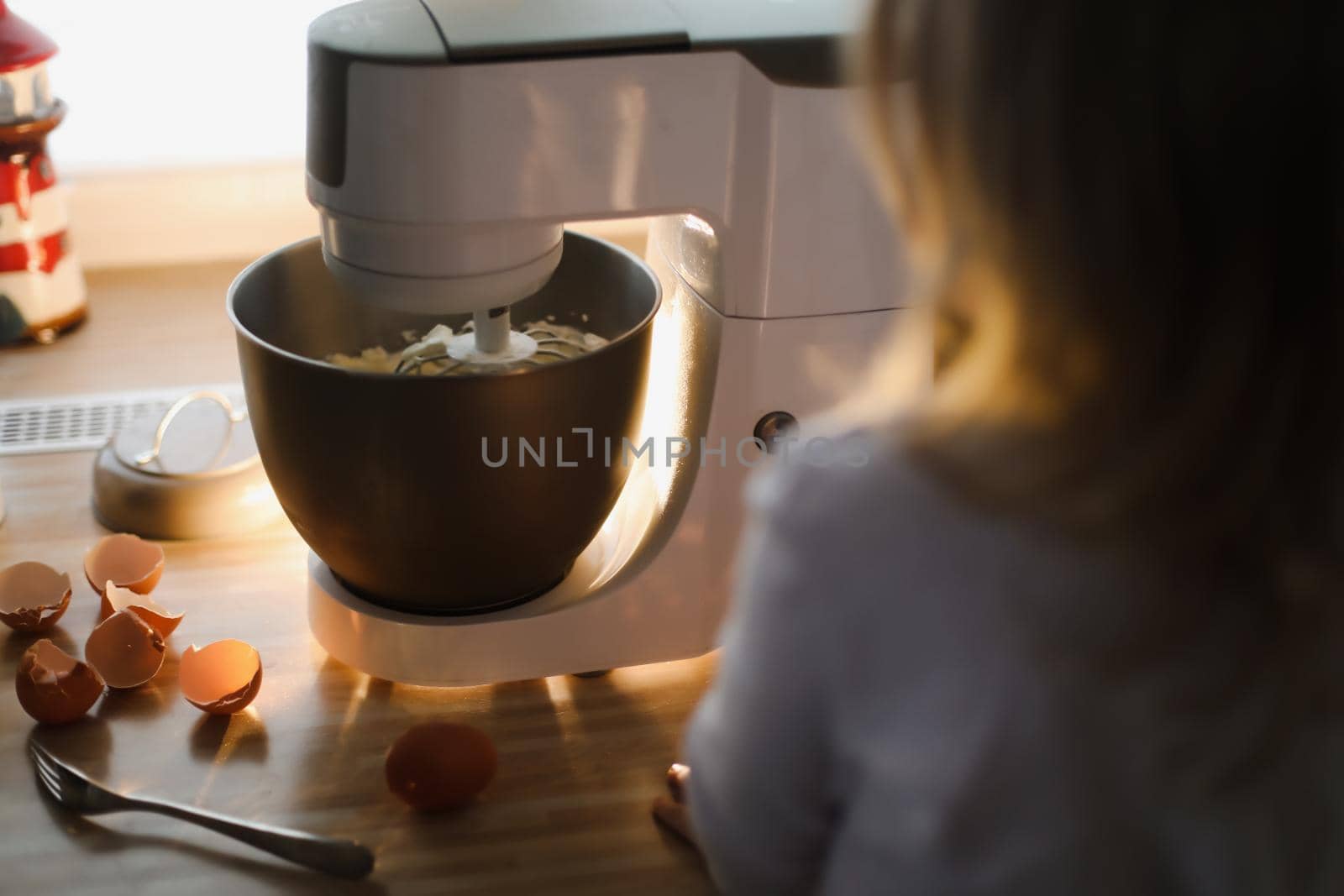 child looking at planetary mixer and baking pie in a cozy kitchen at home. High quality photo