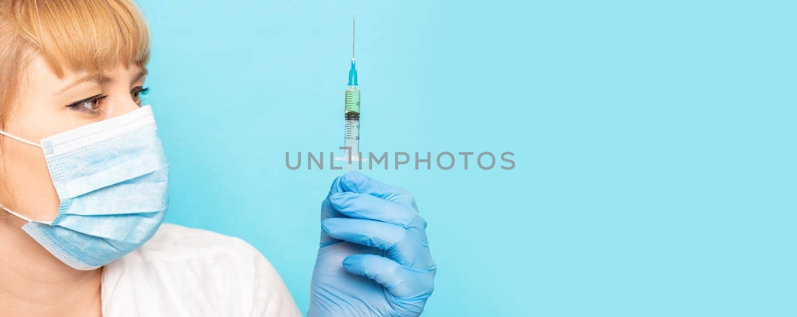 Doctor with a syringe in his hands. Selective focus.