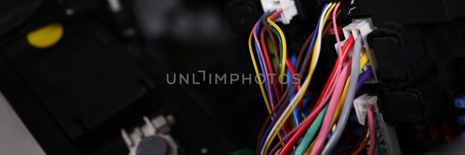 Close-up of large wide cable with multicolored wires and connectors in car. Electric connector plug of car engine. Maintenance for automobile fix concept