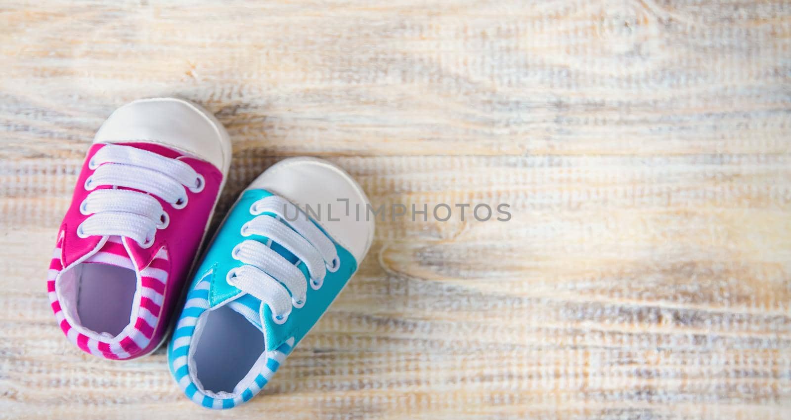 Baby booties and accessories on a light background. Selective focus.