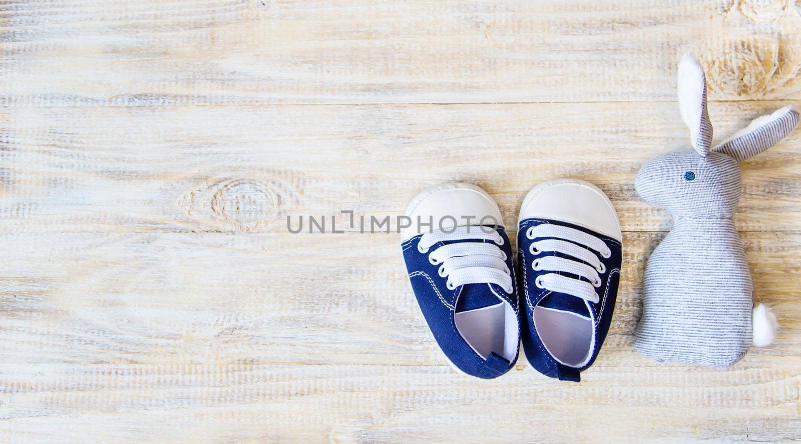 Baby booties and accessories on a light background. Selective focus.