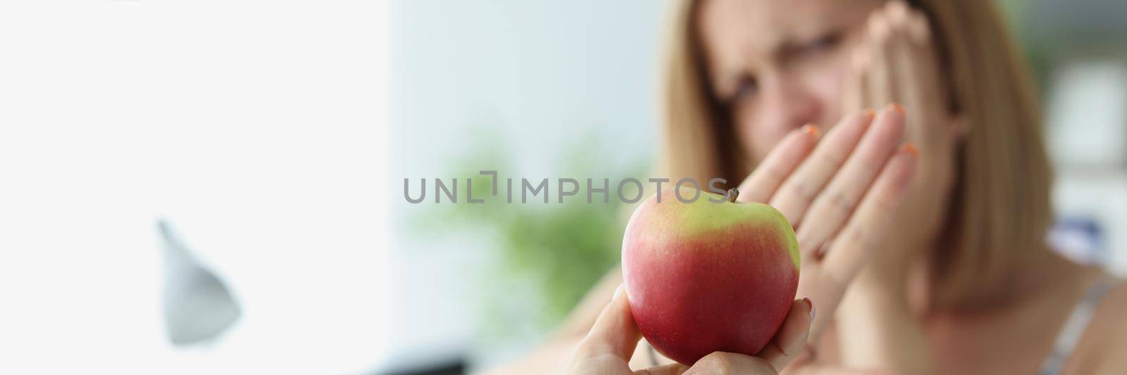 Blonde woman refuse to eat apple because of teeth pain by kuprevich