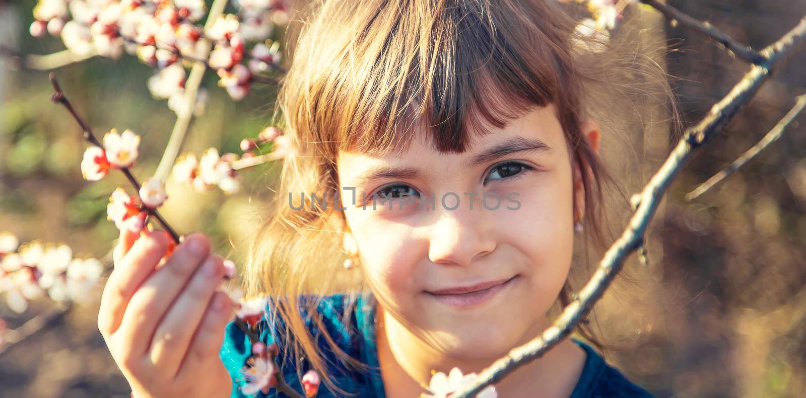 A child in the garden of flowering trees. Selective focus. Nature.