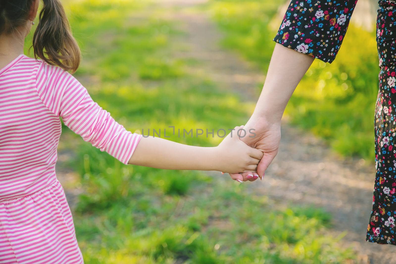 A child with his mother goes by the hand. Selective focus. nature.