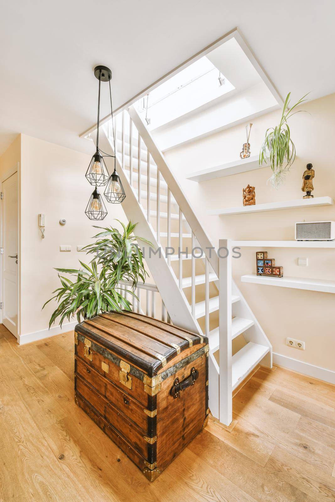 White hallway with wooden stairway leading to second floor of modern luxury apartment with minimalist interior design