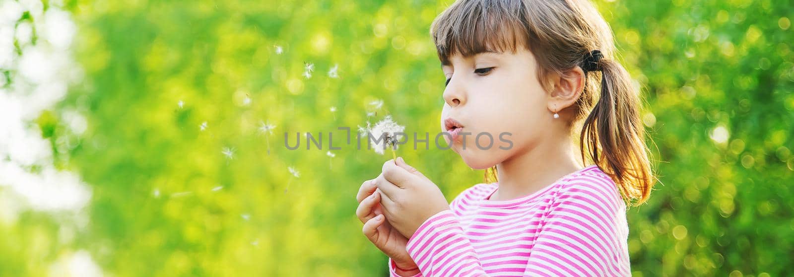 Child girl with dandelions in the park. Selective focus.