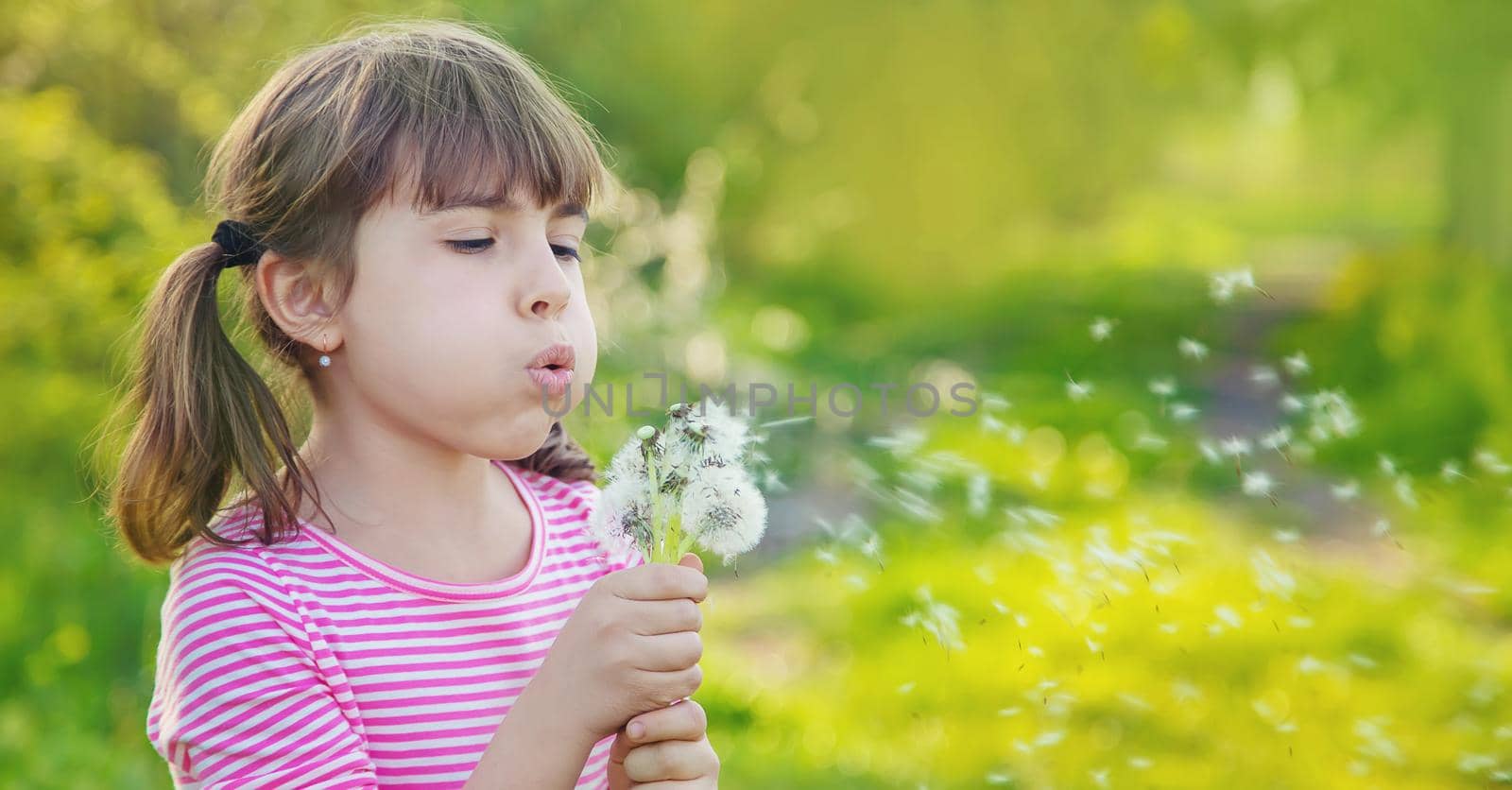 Child girl with dandelions in the park. Selective focus.