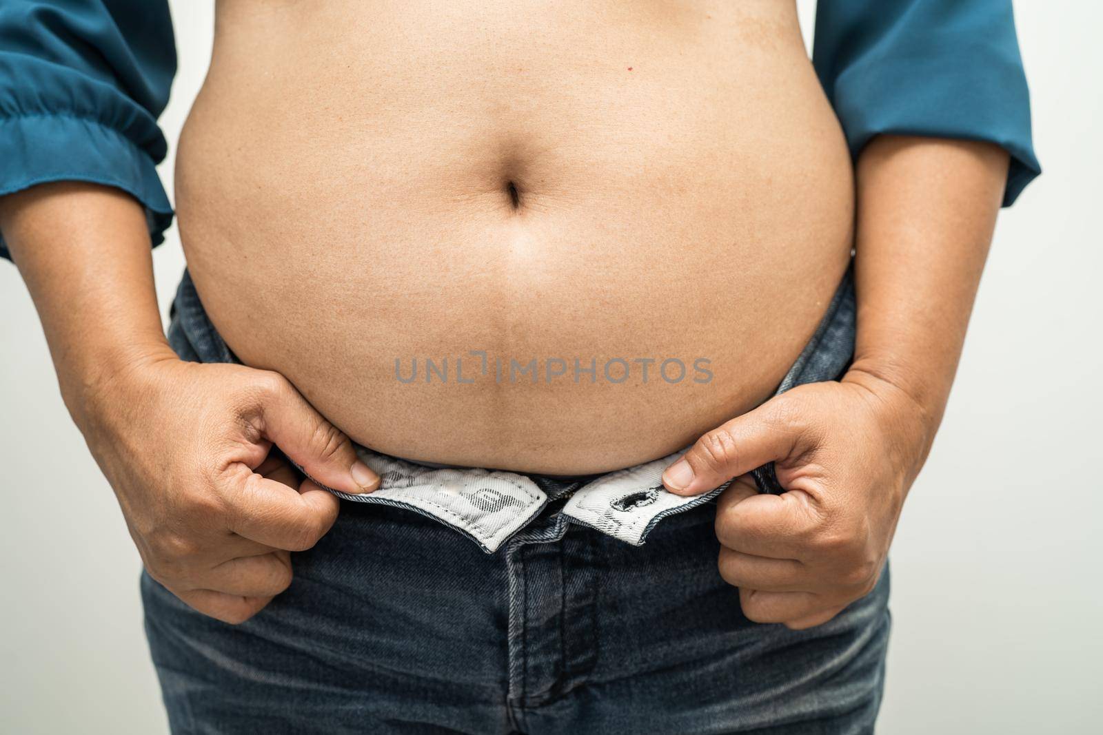 Overweight Asian woman show fat belly at office.
