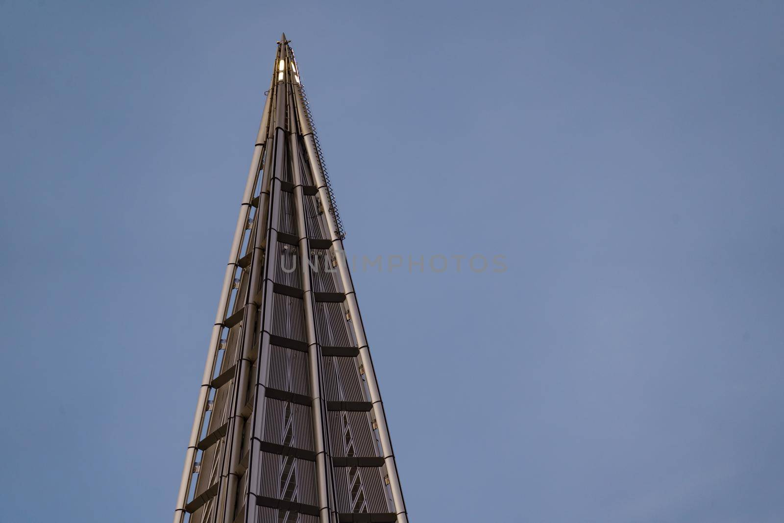 Russia, St. Petersburg, 10 June 2022: The spire of skyscraper Lakhta center of the gas company Gazprom at sunset, glass and iron facade. High quality photo