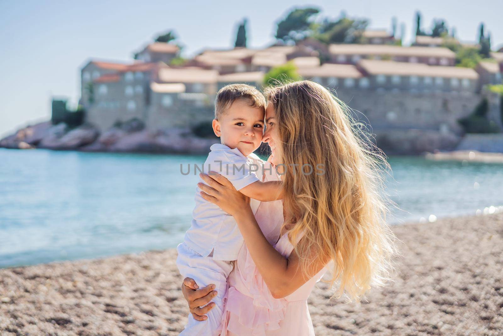 Mother and son tourists on background of beautiful view St. Stephen island, Sveti Stefan on the Budva Riviera, Budva, Montenegro. Travel to Montenegro concept.