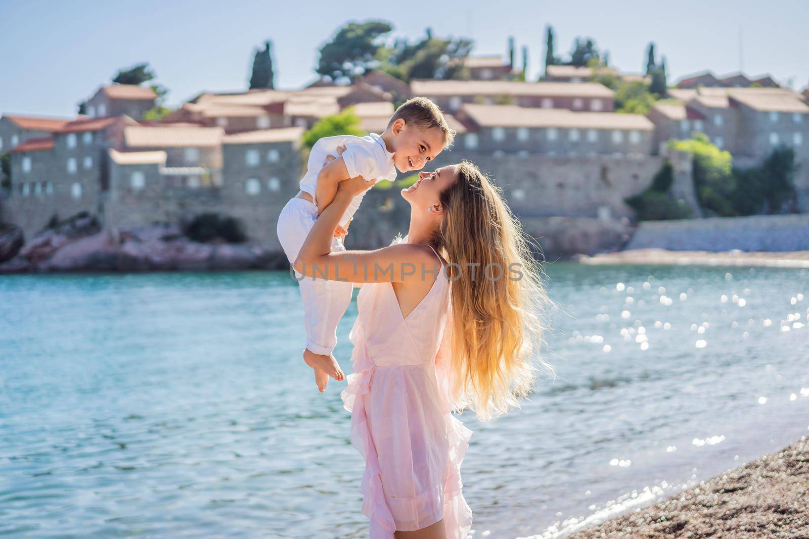 Mother and son tourists on background of beautiful view St. Stephen island, Sveti Stefan on the Budva Riviera, Budva, Montenegro. Travel to Montenegro concept by galitskaya