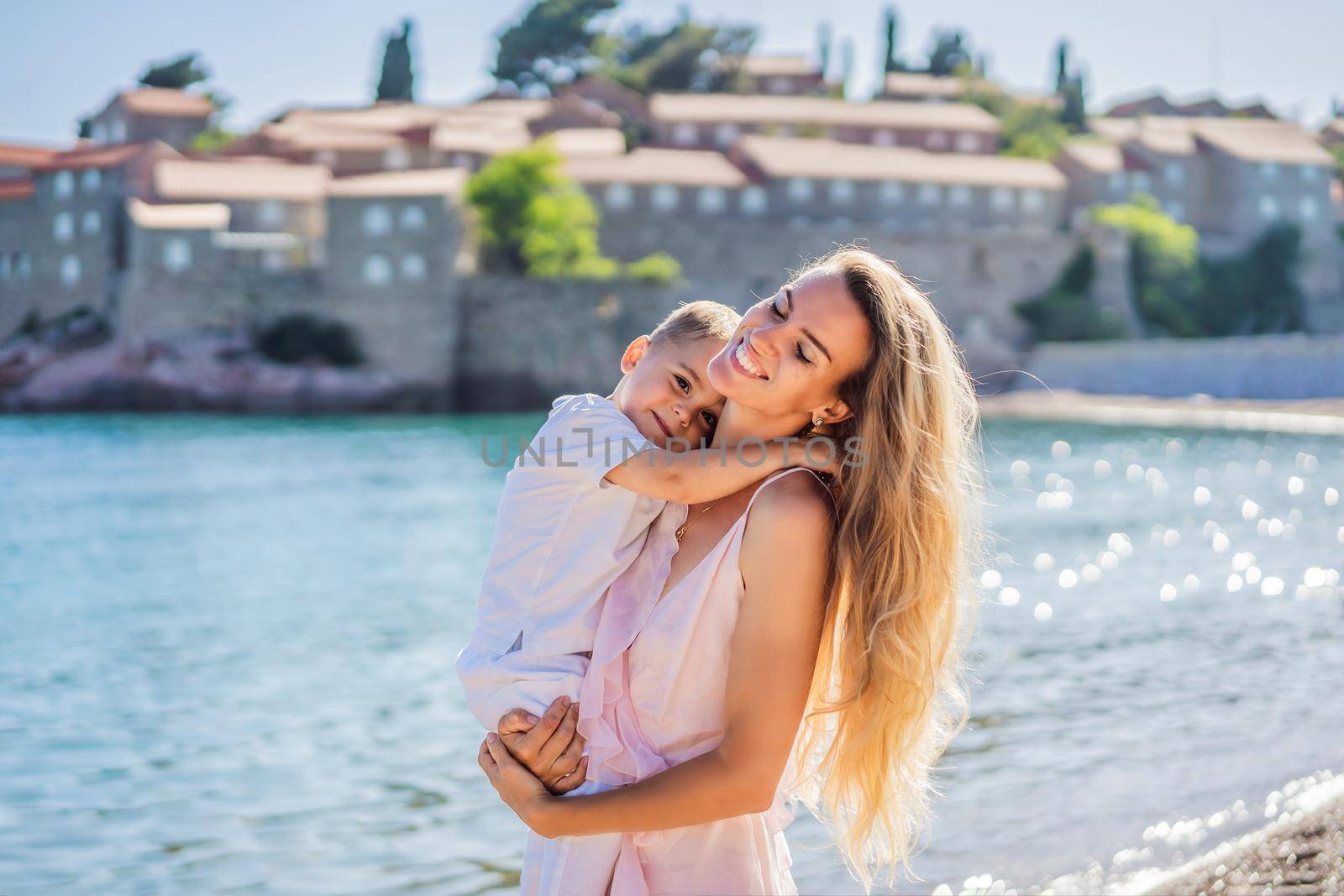 Mother and son tourists on background of beautiful view St. Stephen island, Sveti Stefan on the Budva Riviera, Budva, Montenegro. Travel to Montenegro concept by galitskaya
