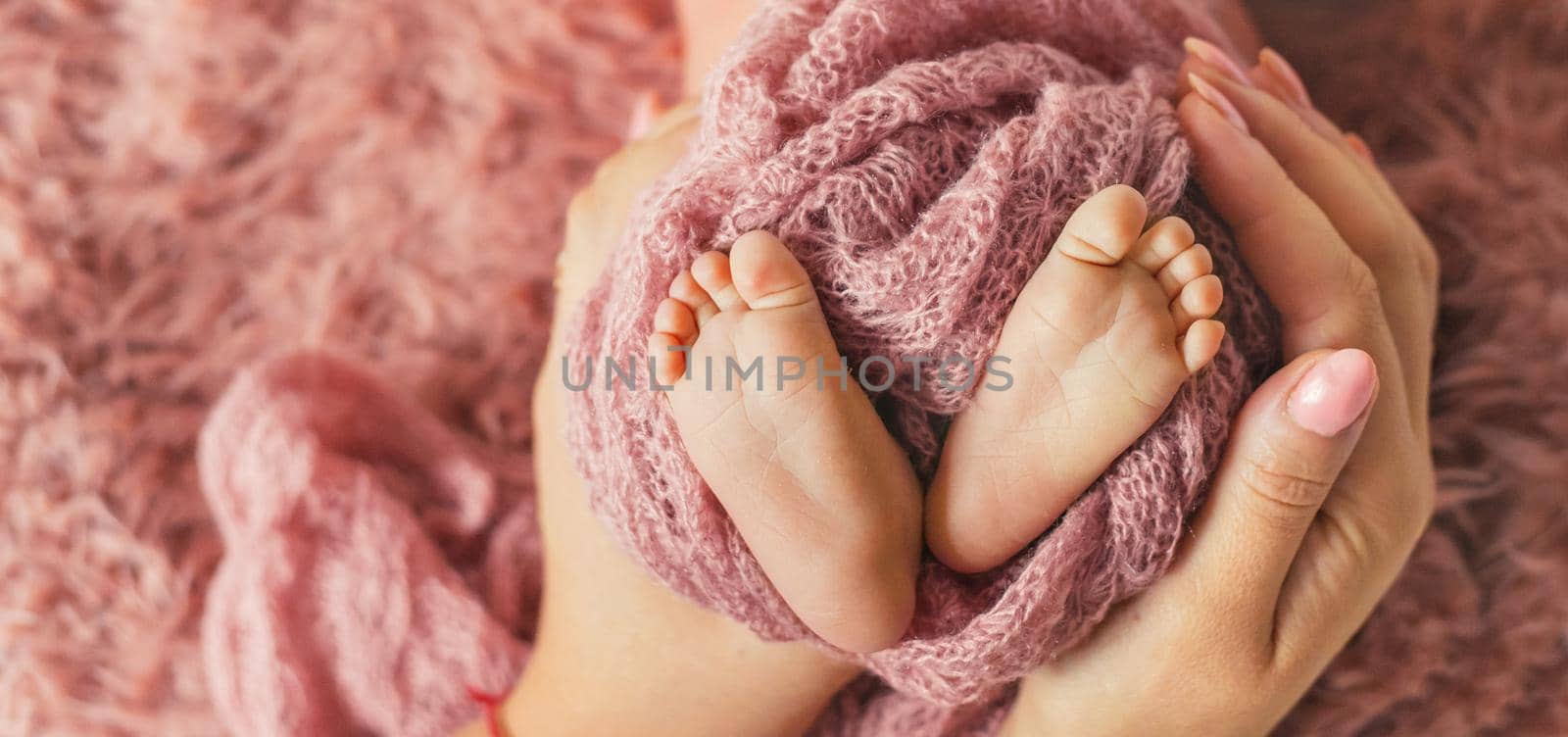 newborn baby mom is holding legs. selective focus. people.