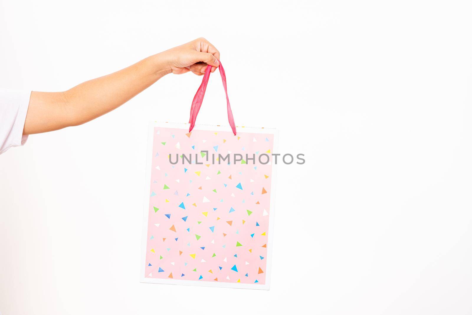 hand holding a colorful pink shopping bag by Sorapop