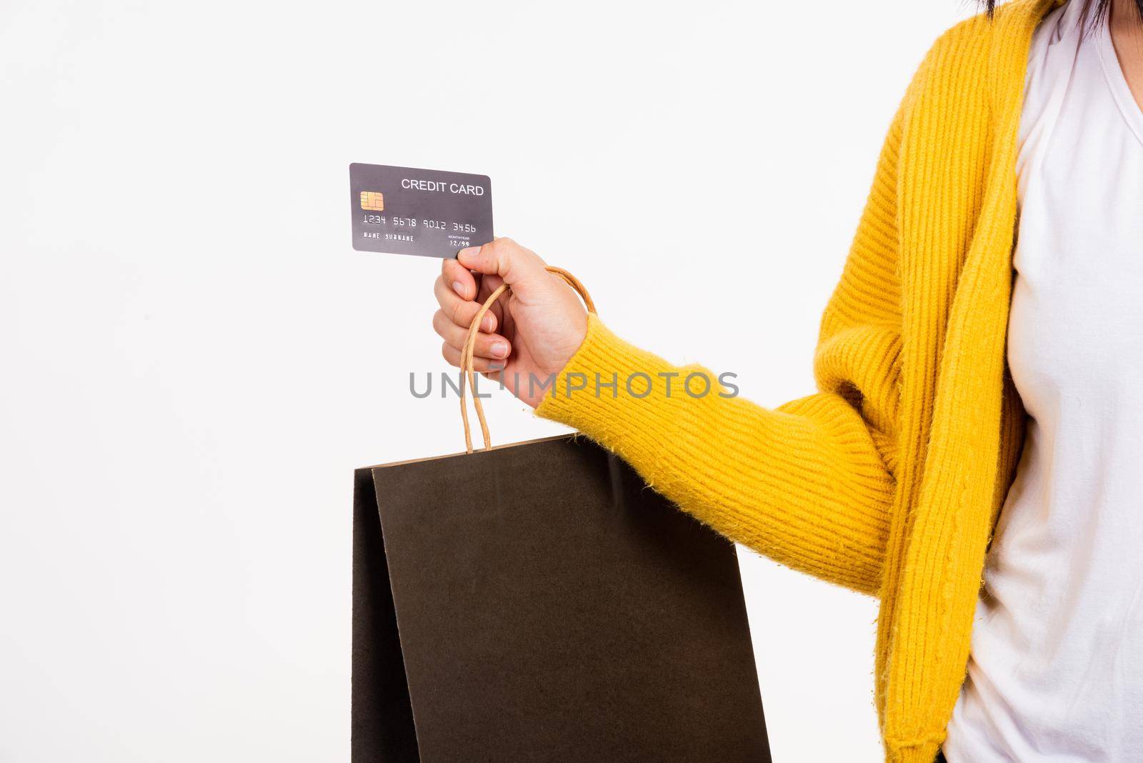 Happy woman hand she wears yellow shirt holding black shopping bags and credit card, young female hold black packets within arms isolated on white background, Black Friday sale concept
