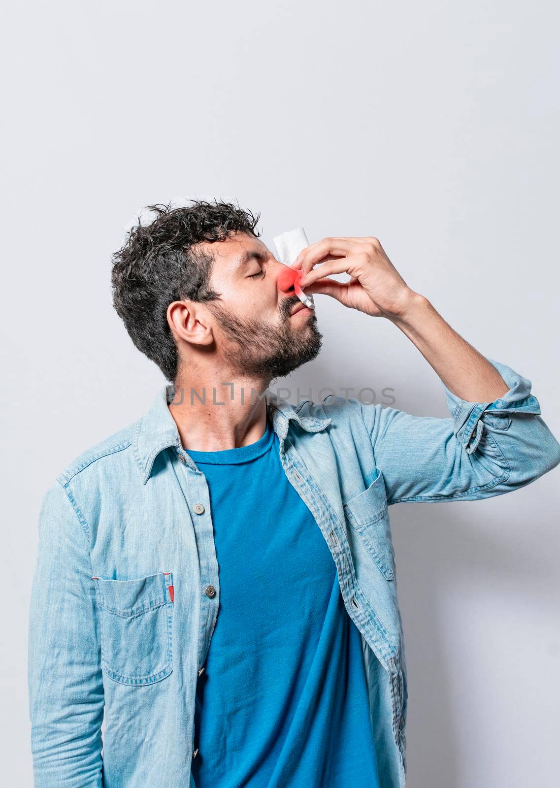 Person with nasal congestion, Person with irritated nose on isolated background, man with red nose cold, concept of person with sinusitis by isaiphoto