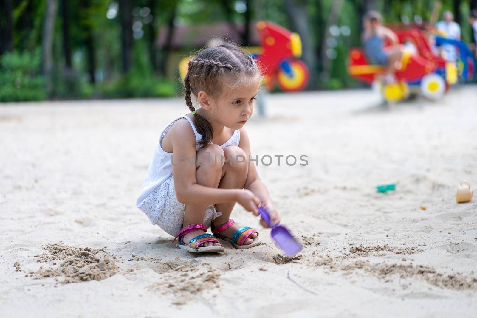 Little Girl Playing Sandbox Playground Digging Sand Shovel Building Sand Figure Summer Day by andreonegin