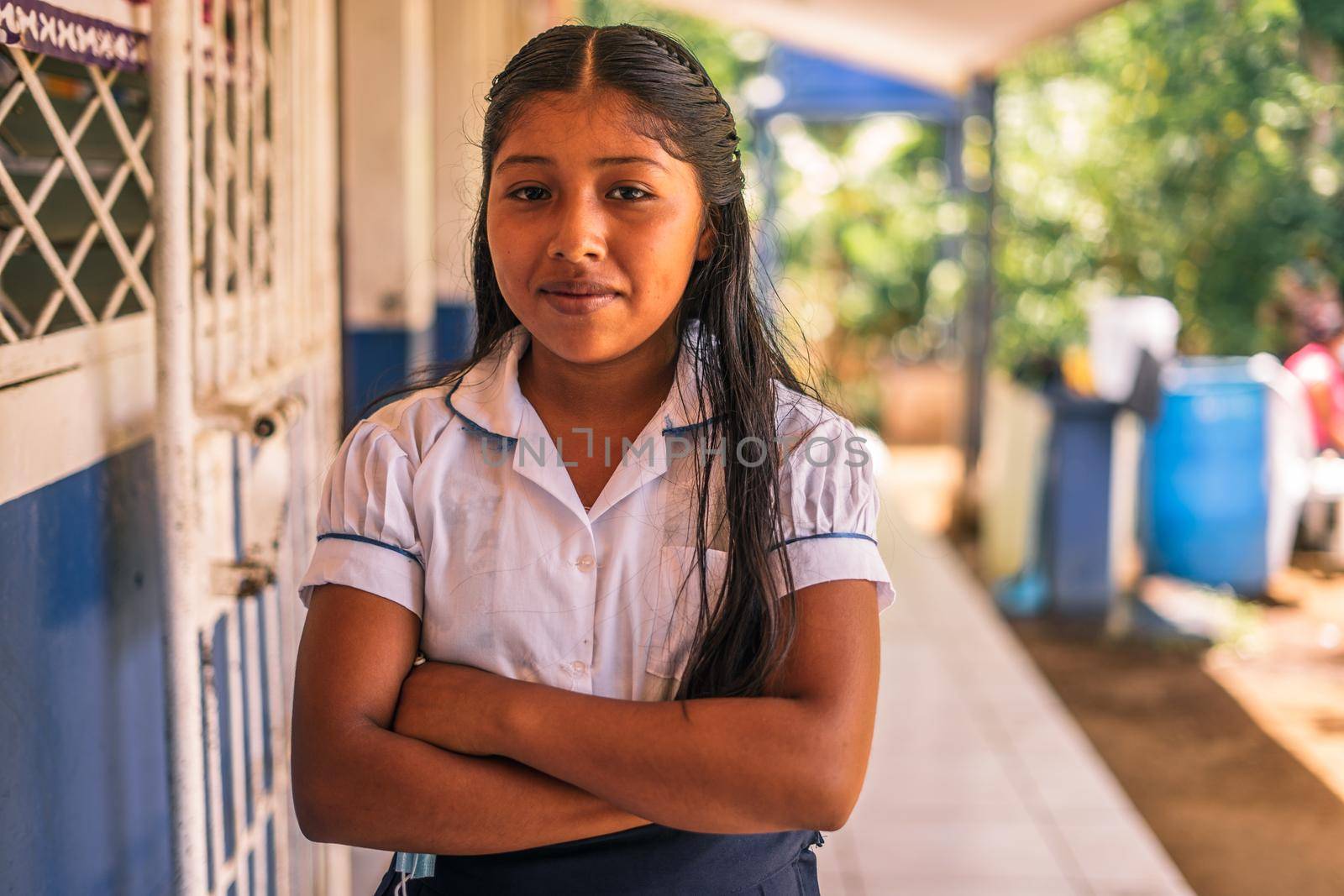 Nicaraguan elementary student girl smiling and looking at the camera with her arms crossed in a school in Masaya by cfalvarez