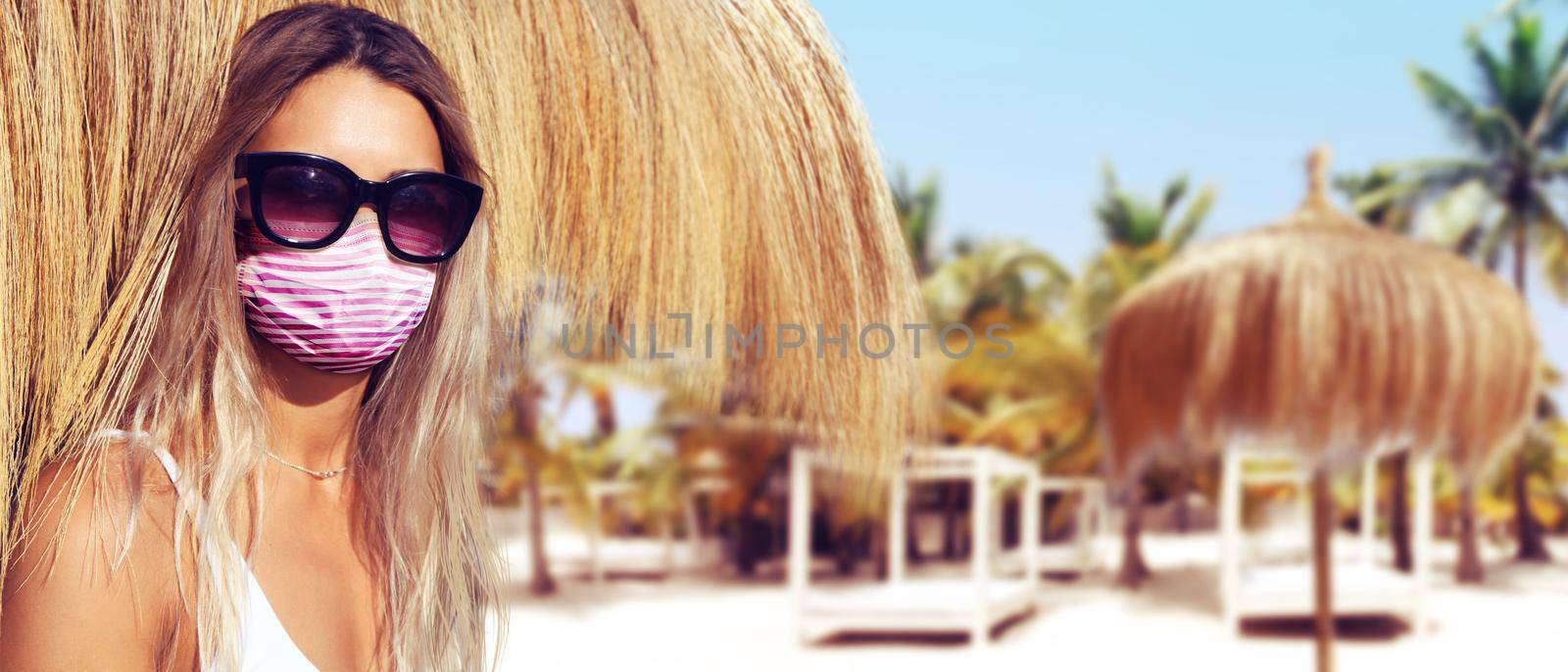Beautiful tourist woman with corona virus mask at the beach by Taut