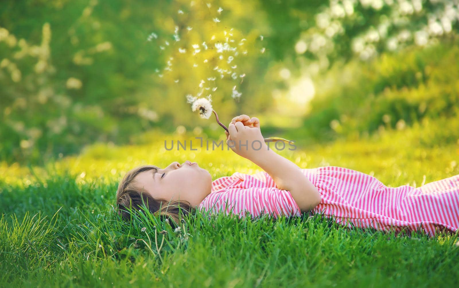 Child girl with dandelions in the park. Selective focus.