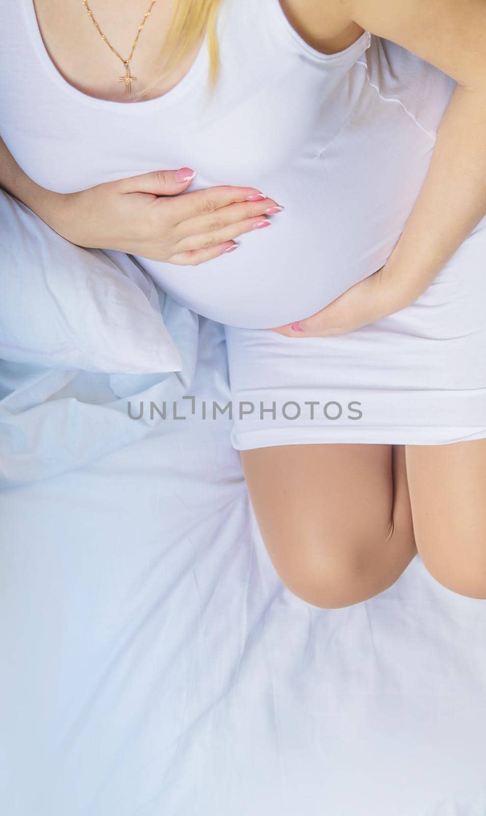 A pregnant woman hugs her belly. Selective focus. People.