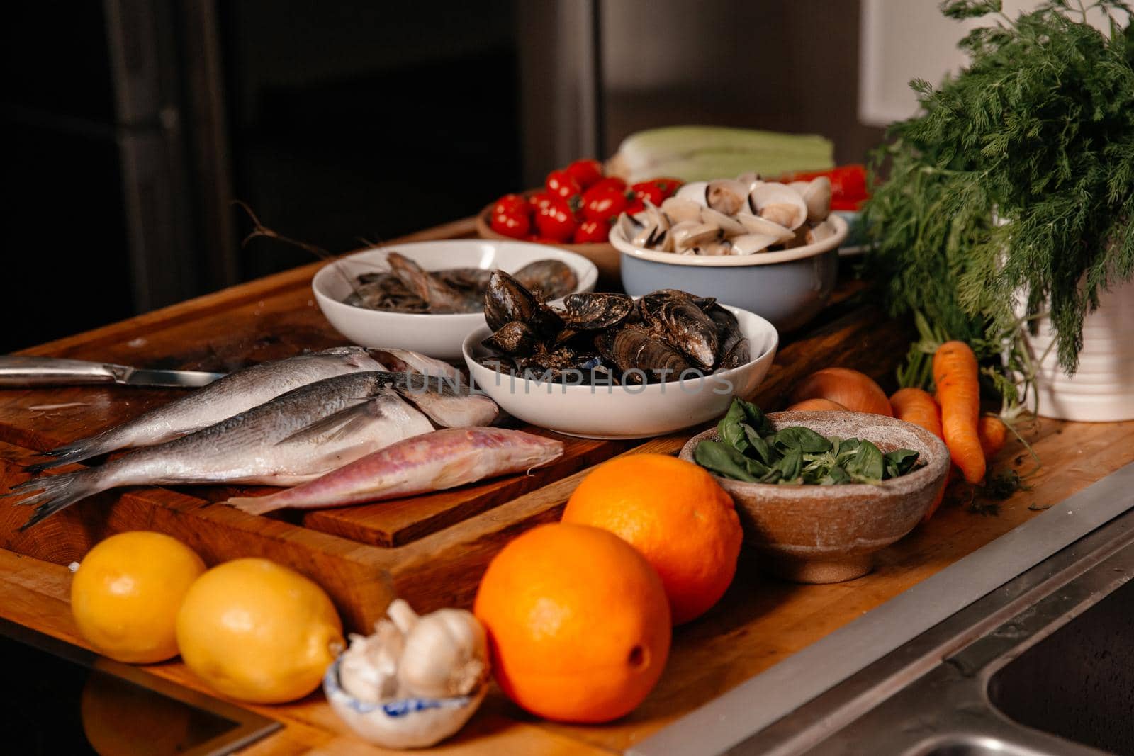 Sea bream and shells on the table next to vegetables and fruit. Ingredients for making a delicious soup.