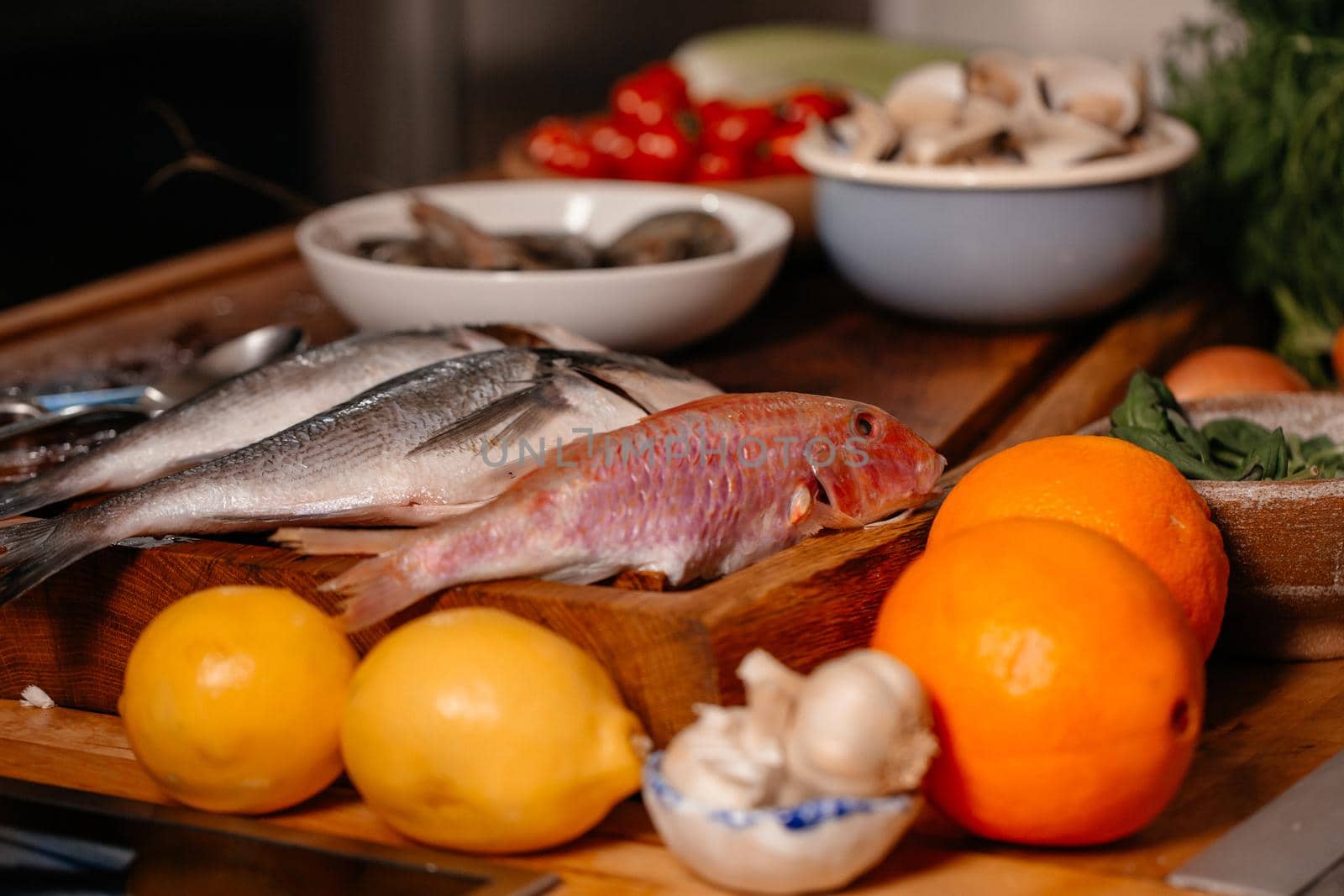 Sea bream and shells on the table next to vegetables and fruit. Ingredients for making a delicious soup. Fine cuisine.