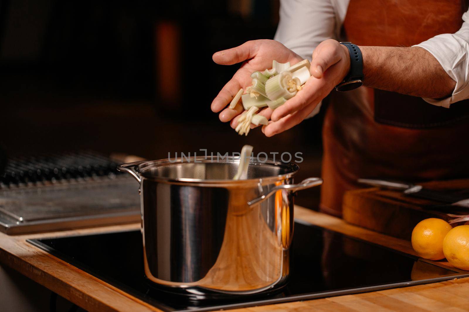 Prepping celery on cutting board ingredients in a large kitchen by RecCameraStock