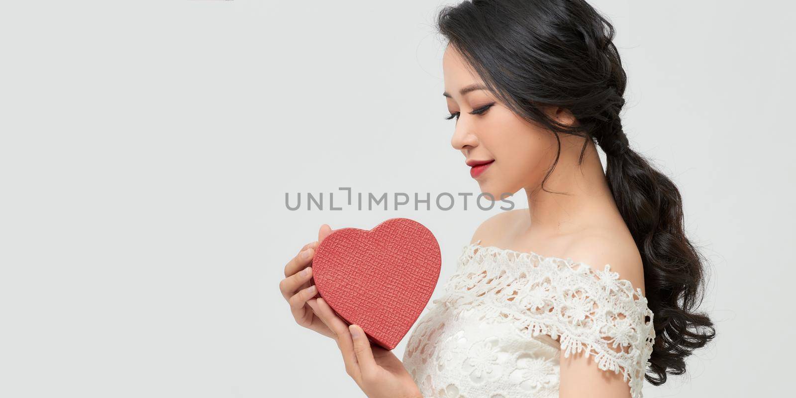 Young happy woman with a gift. Concept of the New Year, Christmas and Valentine's Day.