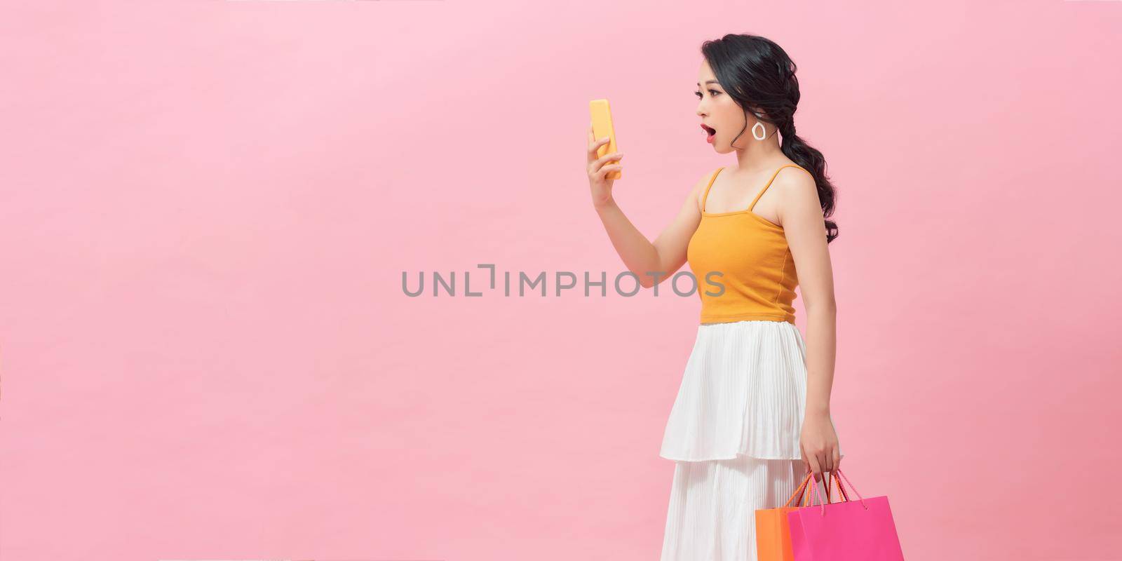 Woman hold with shopping bag and look at smartphone
