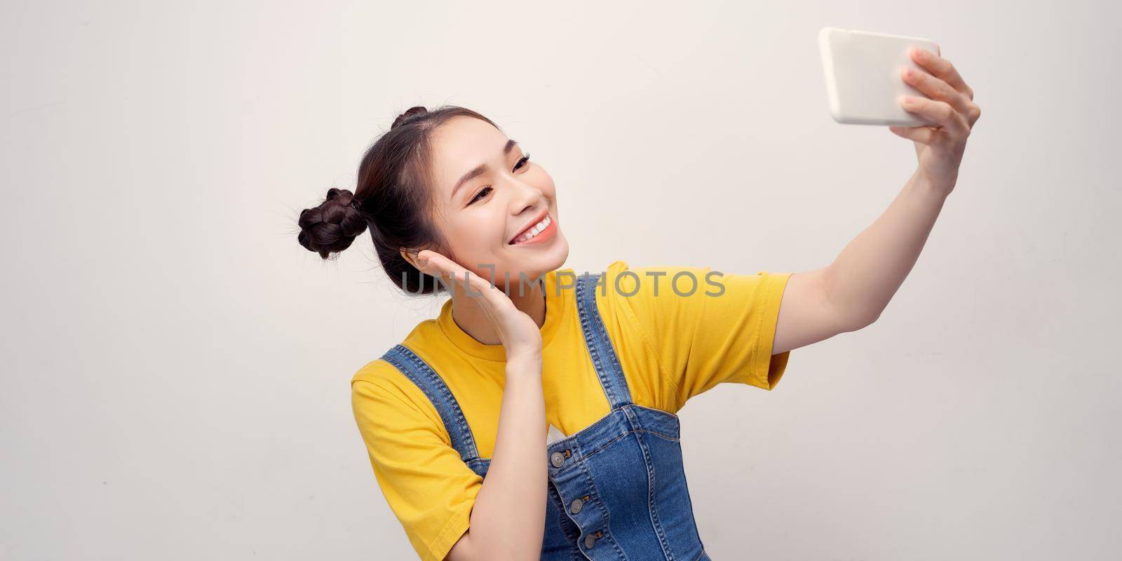 Selfie time. Joyful young women making selfie by her smart phone by makidotvn