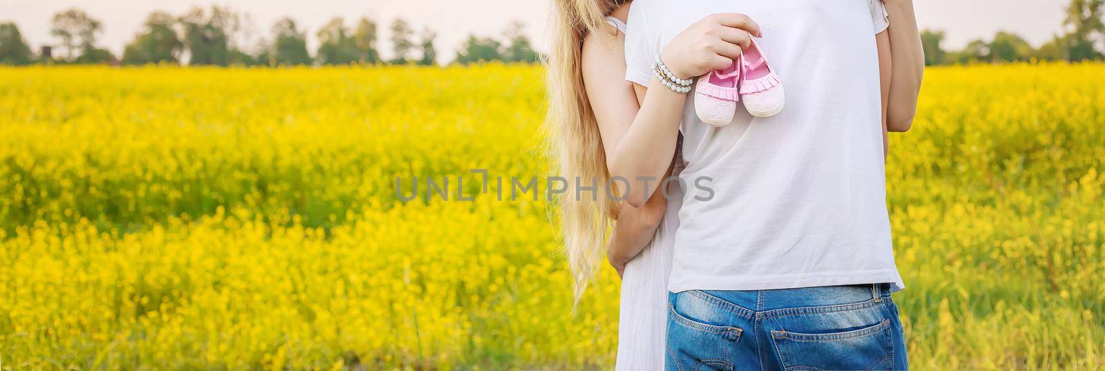 pregnant woman and man hold baby shoes. Selective focus. nature.