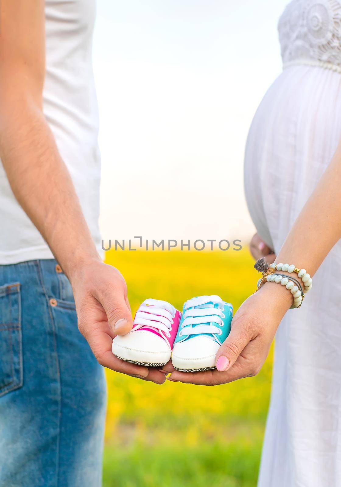 pregnant woman and man hold baby shoes. Selective focus. nature.