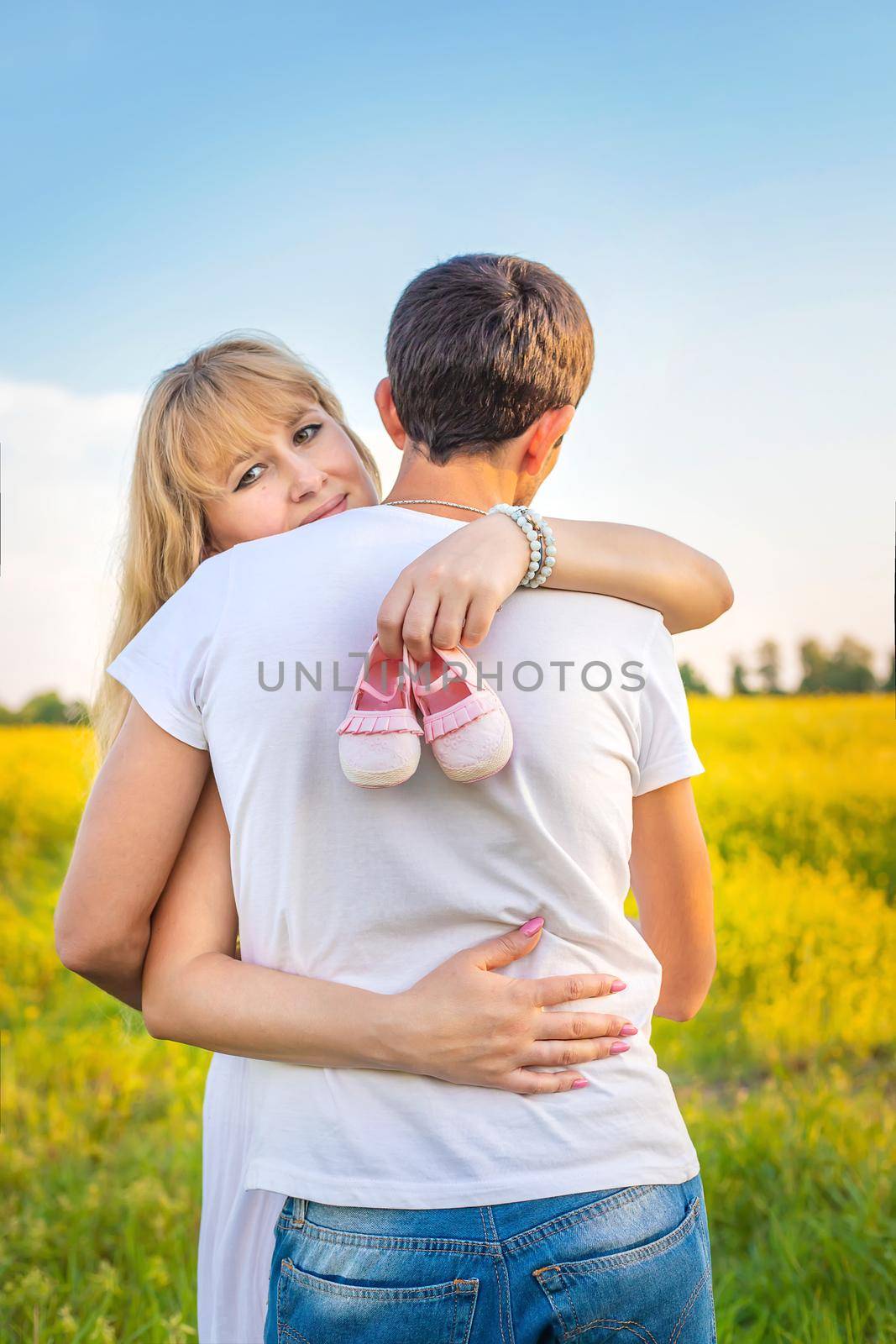 pregnant woman and man hold baby shoes. Selective focus. nature.