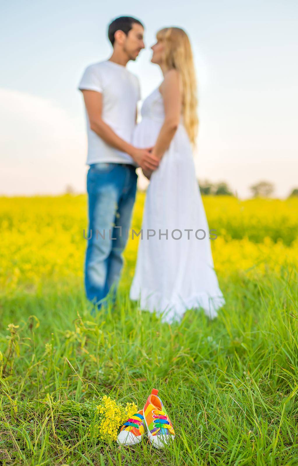 pregnant woman and man hold baby shoes. Selective focus. nature.