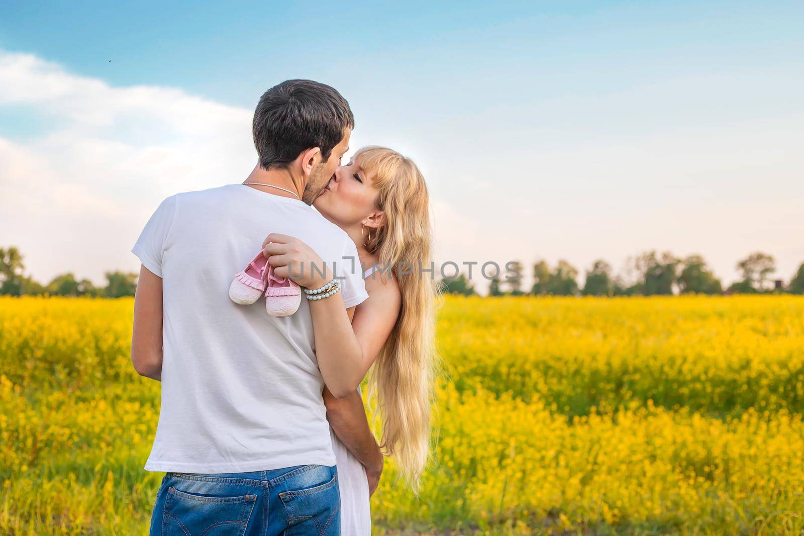 pregnant woman and man hold baby shoes. Selective focus. nature.