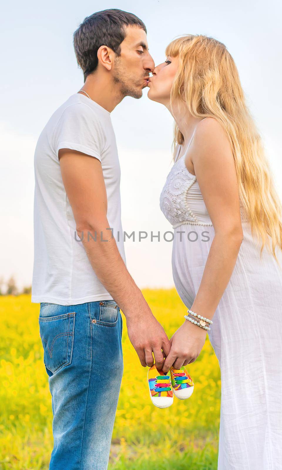 pregnant woman and man hold baby shoes. Selective focus. by yanadjana