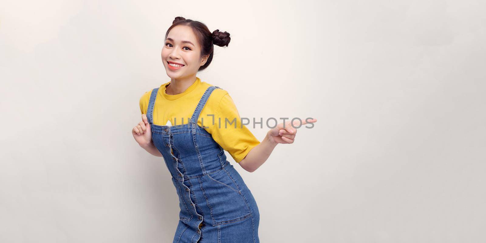 Attractive stylish girl pointing side, advertise promo, smiling camera, look at you as recommend use link, white background