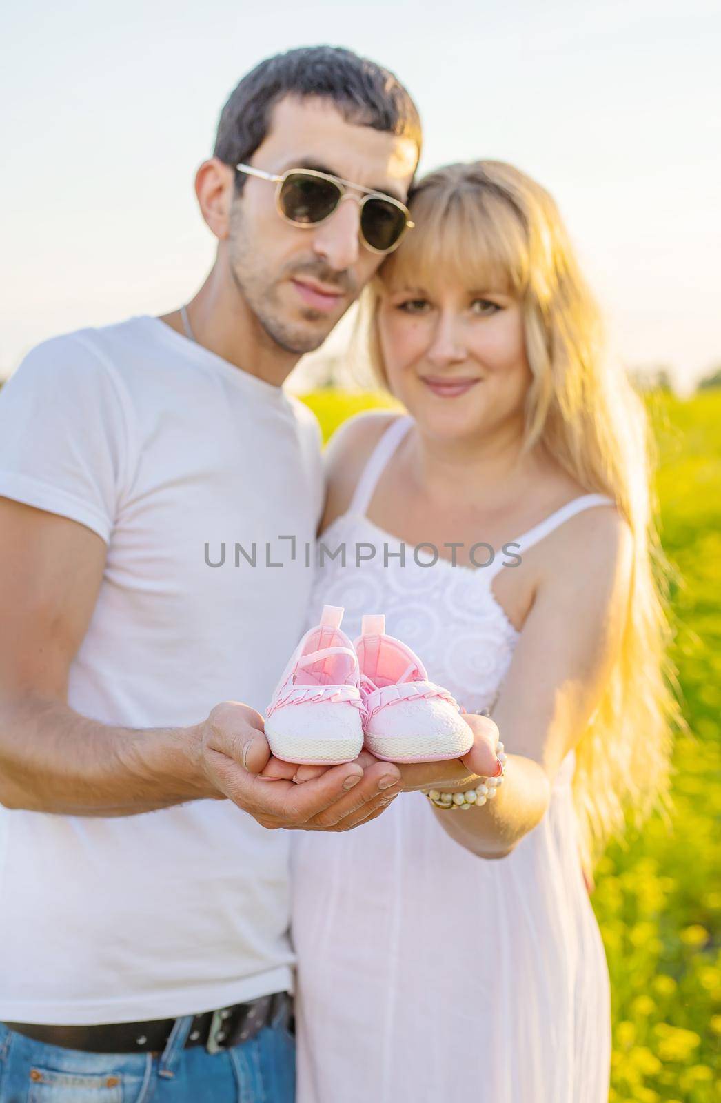 pregnant woman and man hold baby shoes. Selective focus. nature.