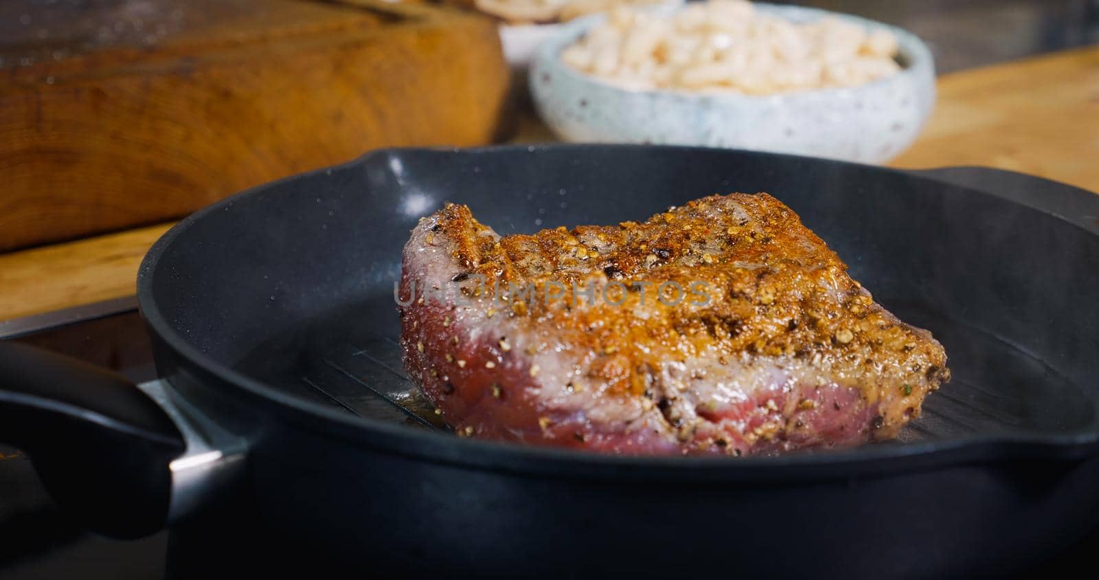 Beef Meat Steak Cooking on Grill. Hot Pan.