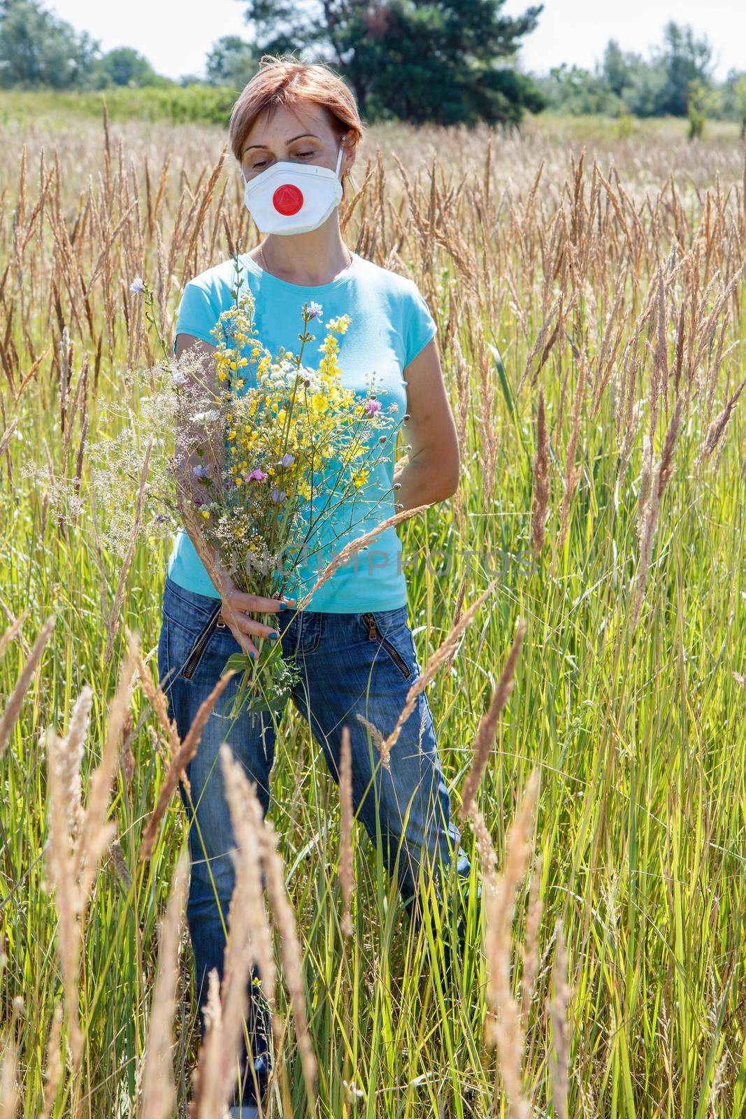 Woman in protective mask holding bouquet of wildflowers by mvg6894