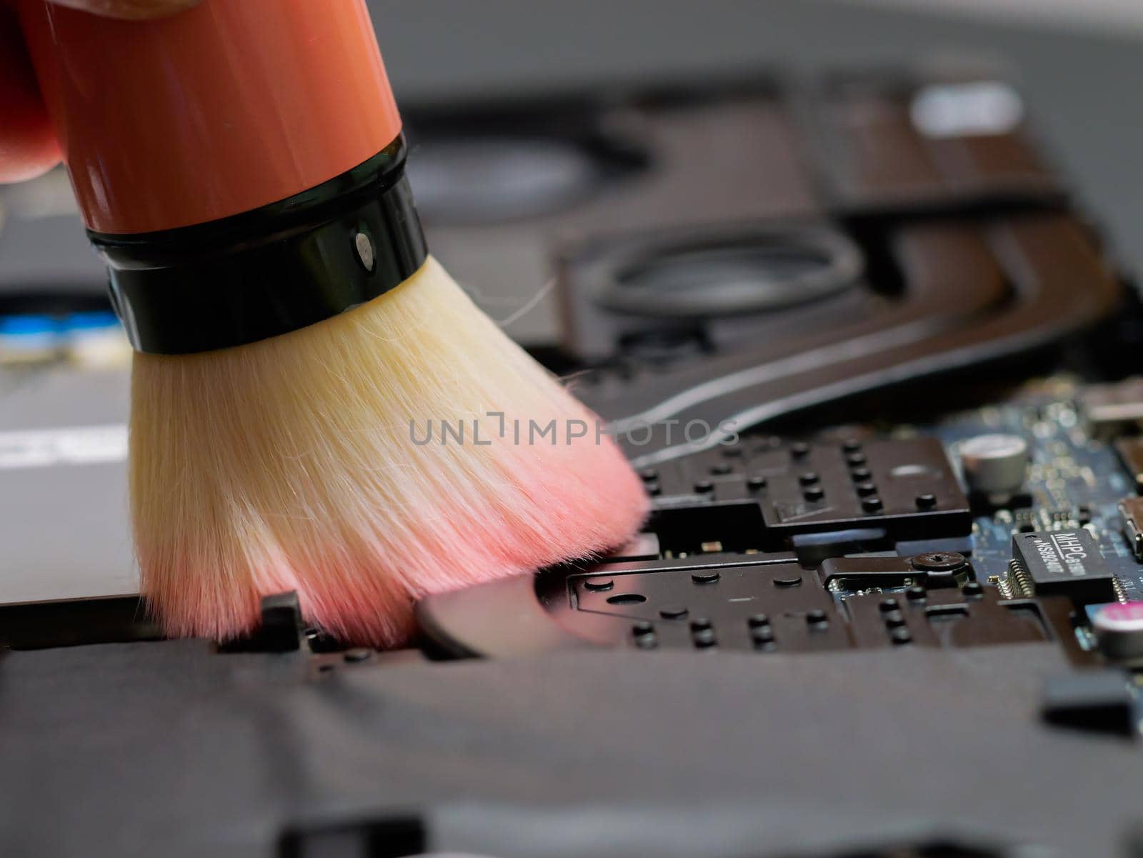 Macro of a brush cleaning a laptop motherboard at a professional service. by RecCameraStock