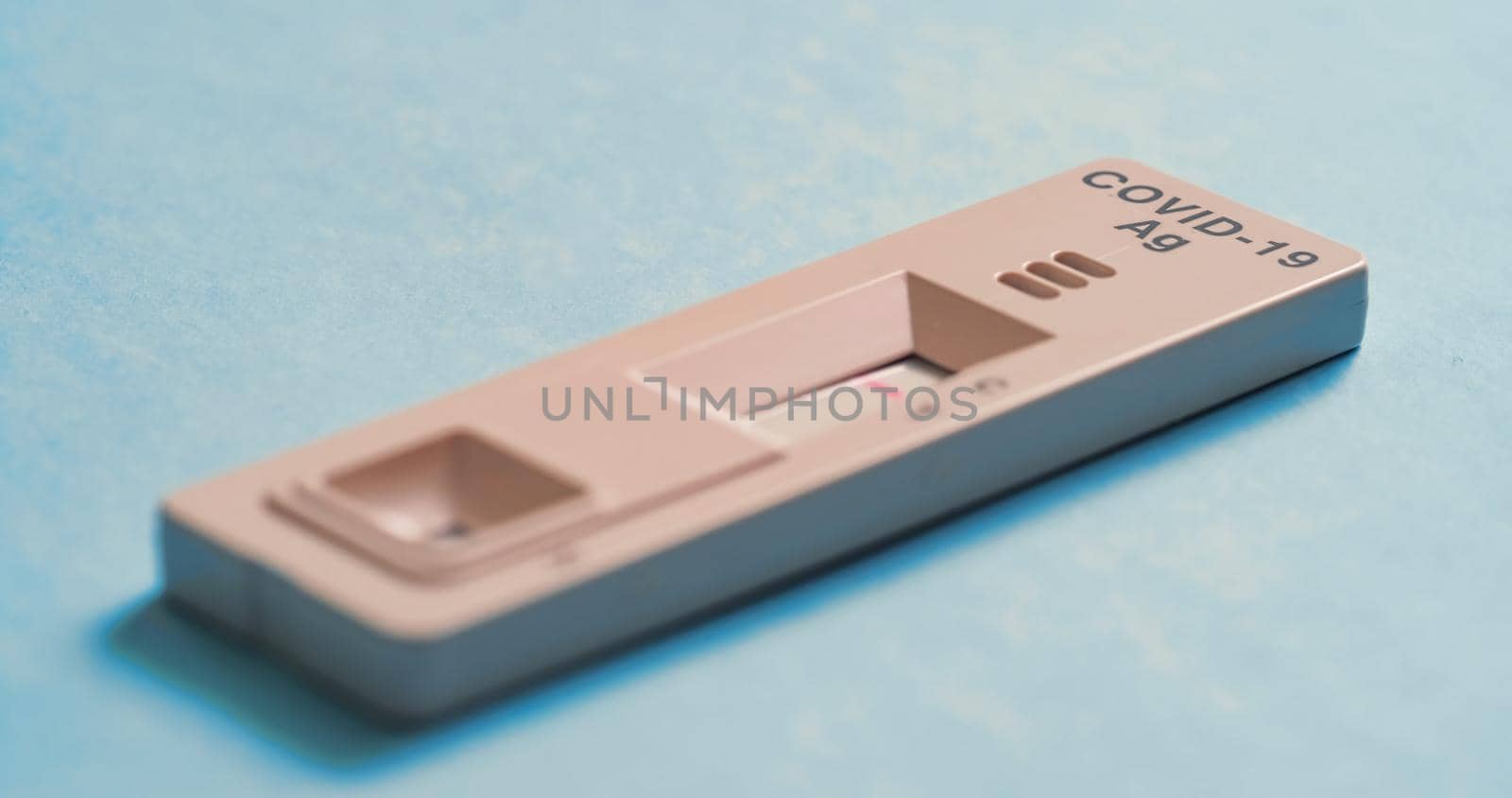 Covid-19 Antigen Test - Sars COV 2 indicator on a blue background. The test result is negative, one strips. Close-up