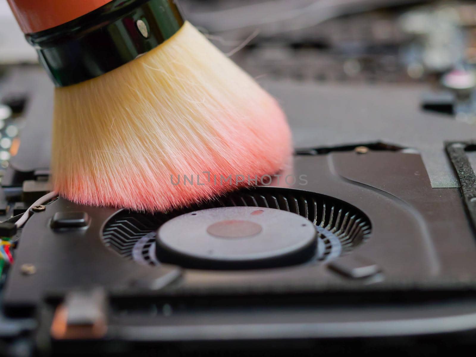 Macro of a brush cleaning a laptop fan at a professional service by RecCameraStock