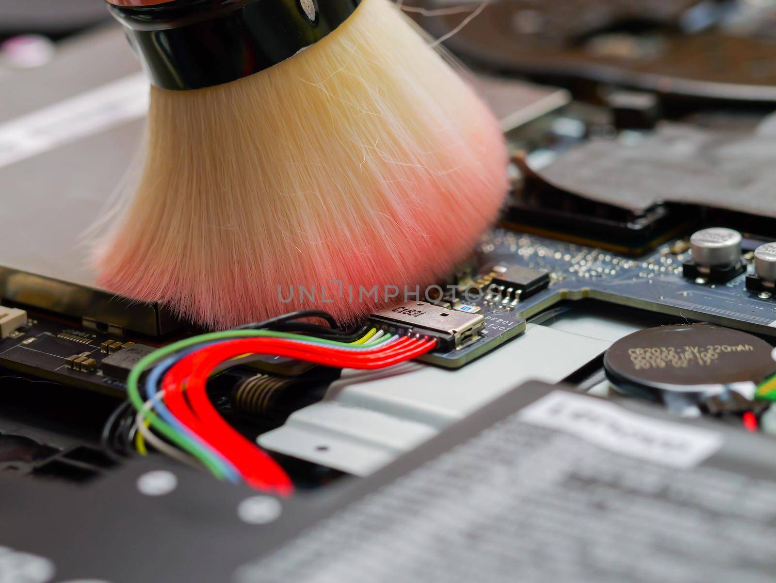 Cleaning a laptop and removing the dust with brush. by RecCameraStock