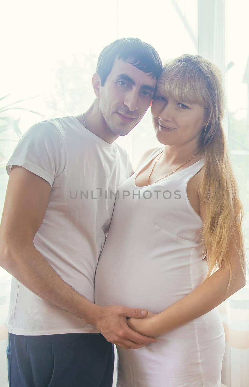 A pregnant woman and a father of a child hug a belly. Selective focus. NATURE.