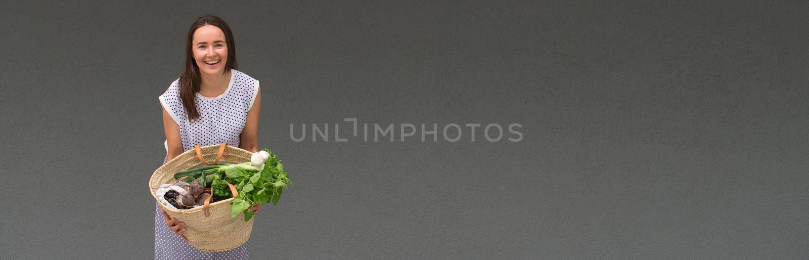 woman is holding straw back for shopping with products without plastic packaging. minimalistic concept