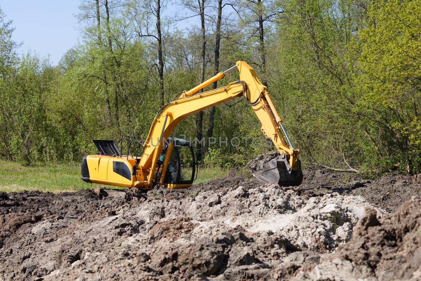 Excavator working at construction site by VitaliiPetrushenko